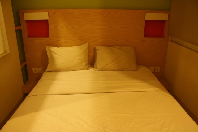 Ranjang, colokan listrik, dan tatakan kayu